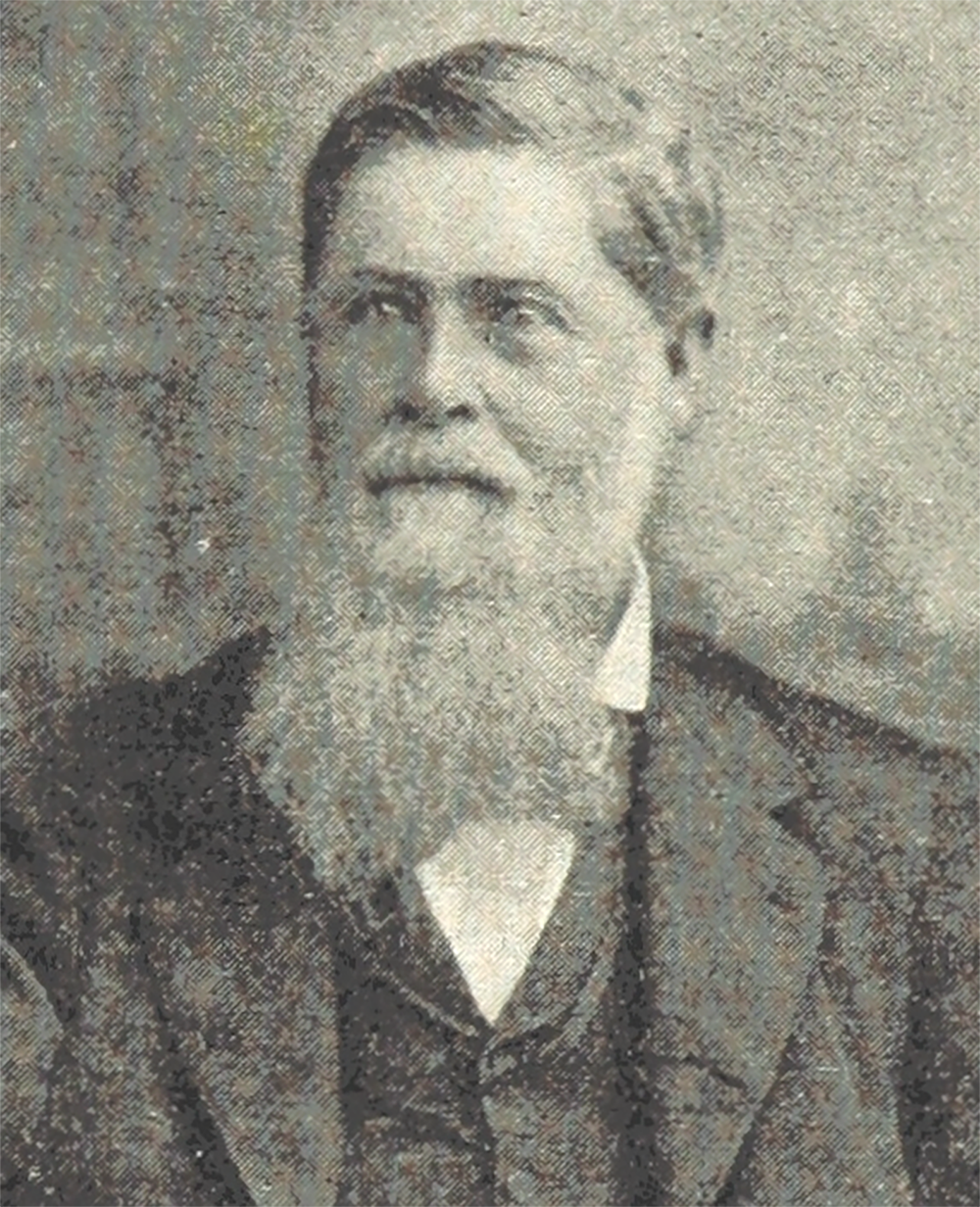 A very old photo of a man from the 1800s shows a formal head and shoulders portrait. He has light eyes and a serious expression.