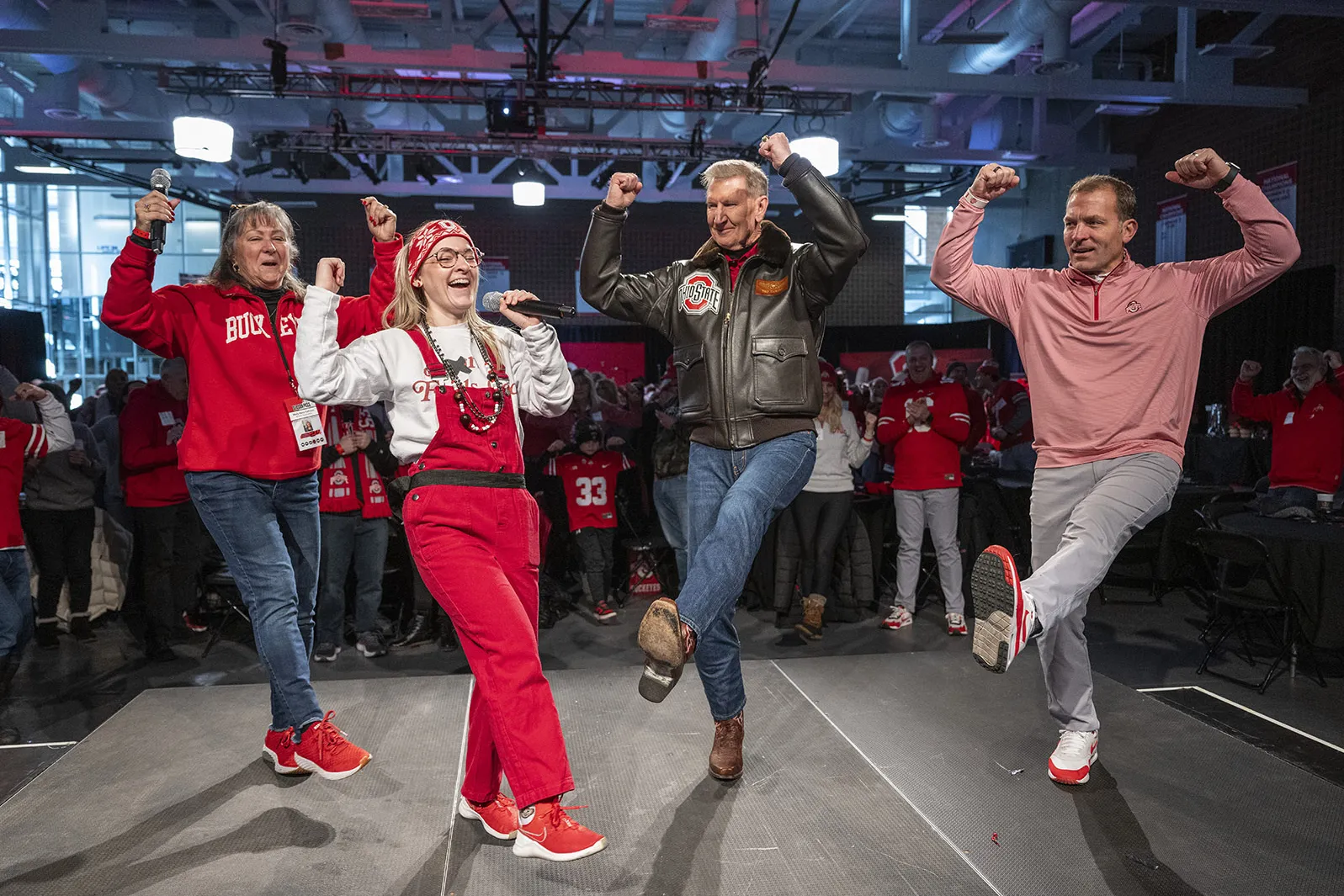 Molly dances on stage with President Carter, Ross Bjork and a young woman wearing scarlet overalls.