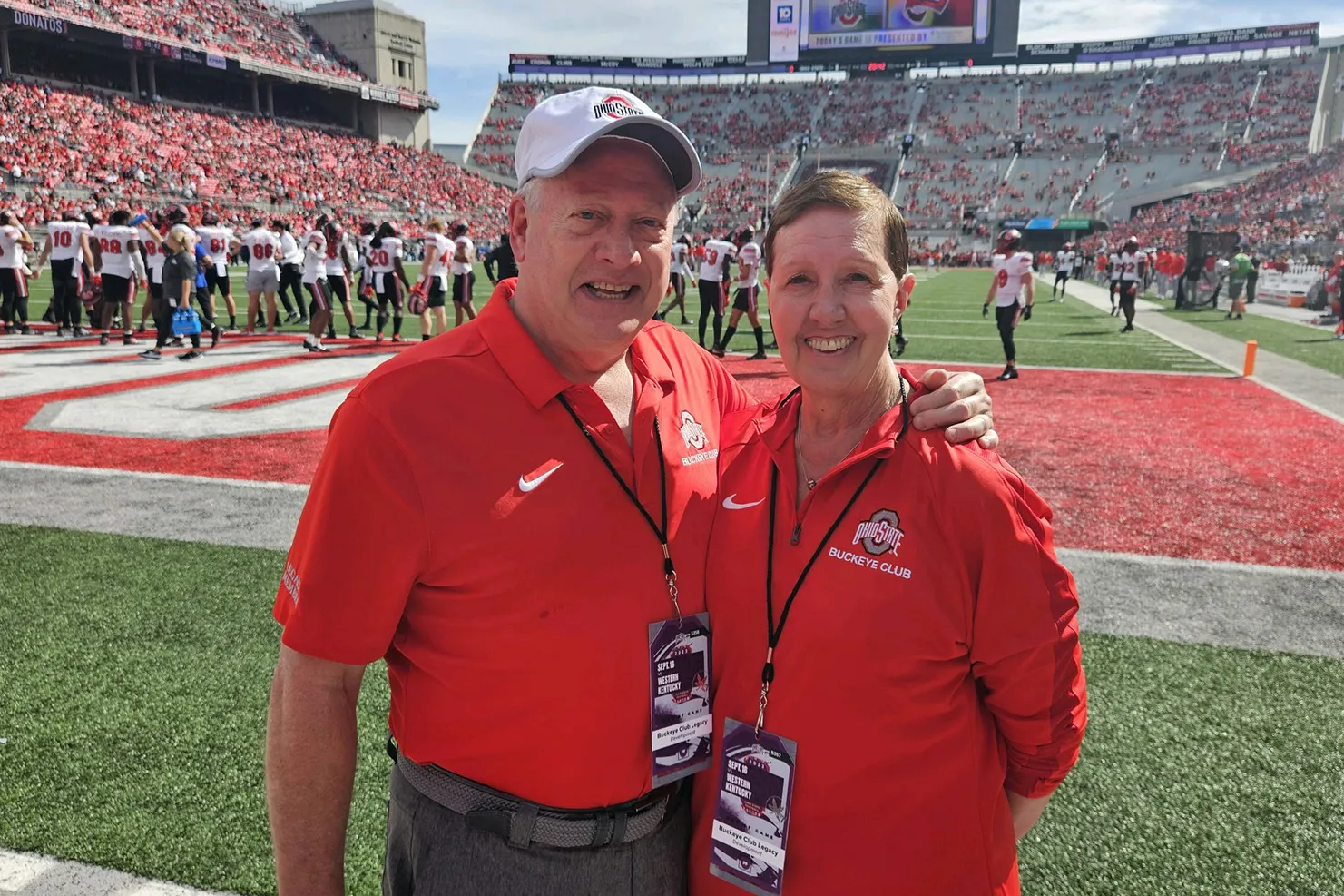 On the field in Ohio Stadium, they grin decades after the previous photos. They're clearly enjoying themselves as Ohio State football players mill around the end zone behind them.
