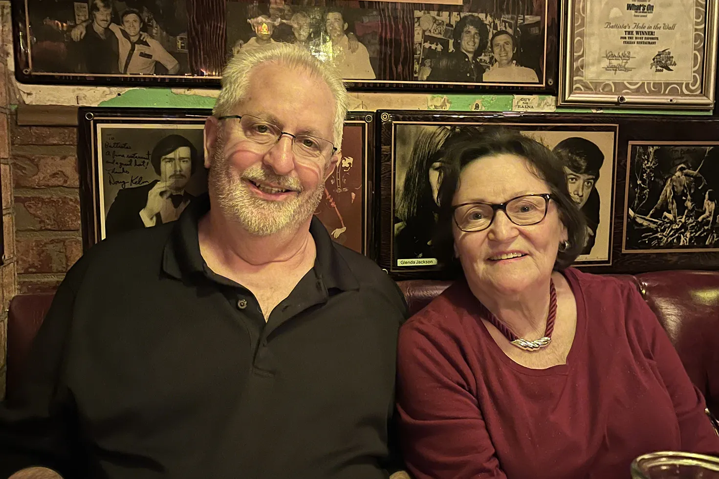 Out for a night at a restaurant these days, the same couple smiles for the camera. They look happy and both still wear glasses, though his hair has turned white.
