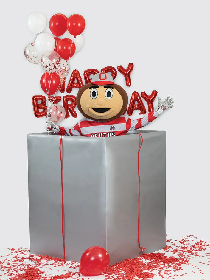 Brutus Buckeye smiles and celebrates from within the gift-wrapped box.