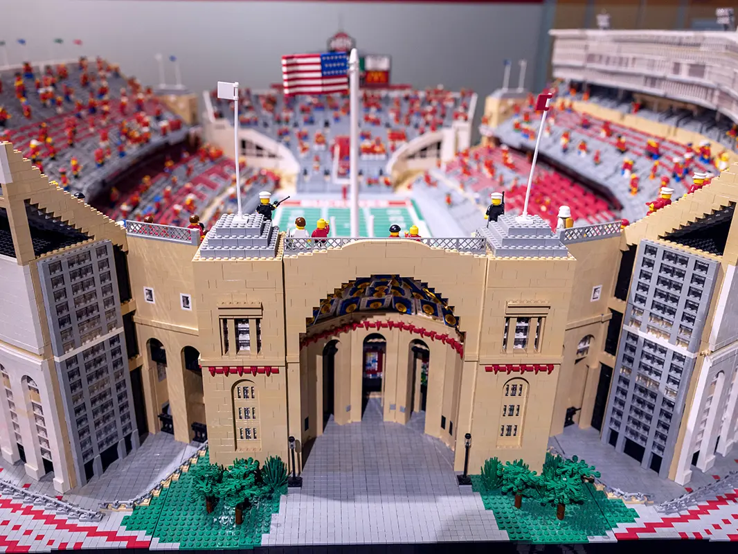 A view of the Lego stadium shows the main rotunda entrance and, beyond, out-of-focus field, stands and Lego people as spectators.