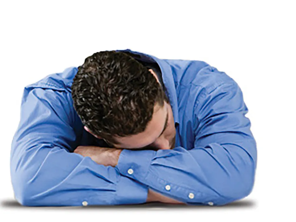 A man sleeps with his head on his crossed arms, as one would on a desk