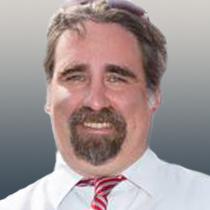 portrait of Aaron Marshall with a white shirt and red tie