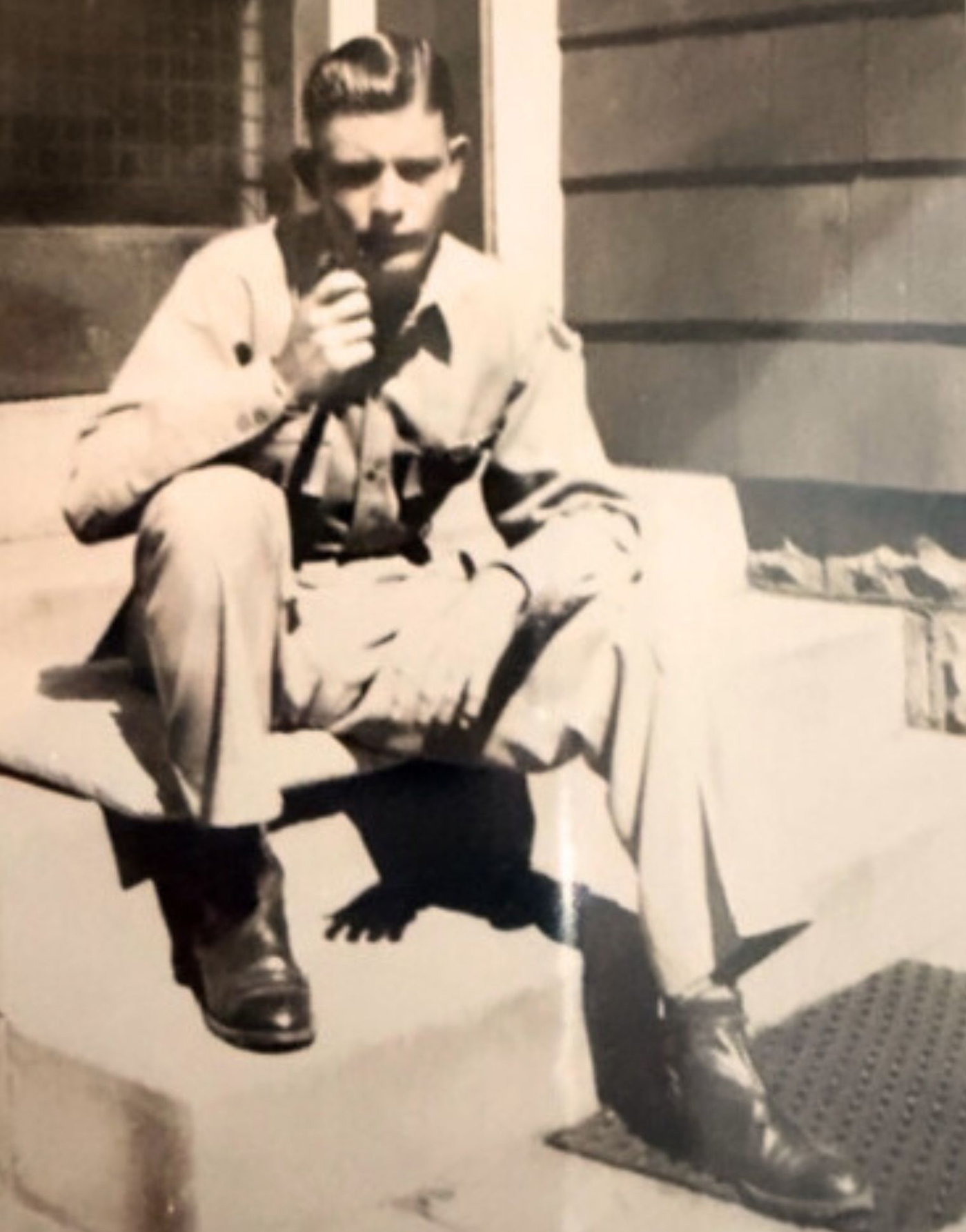 In his Army uniform, Dick Wood sits on the back steps of his home