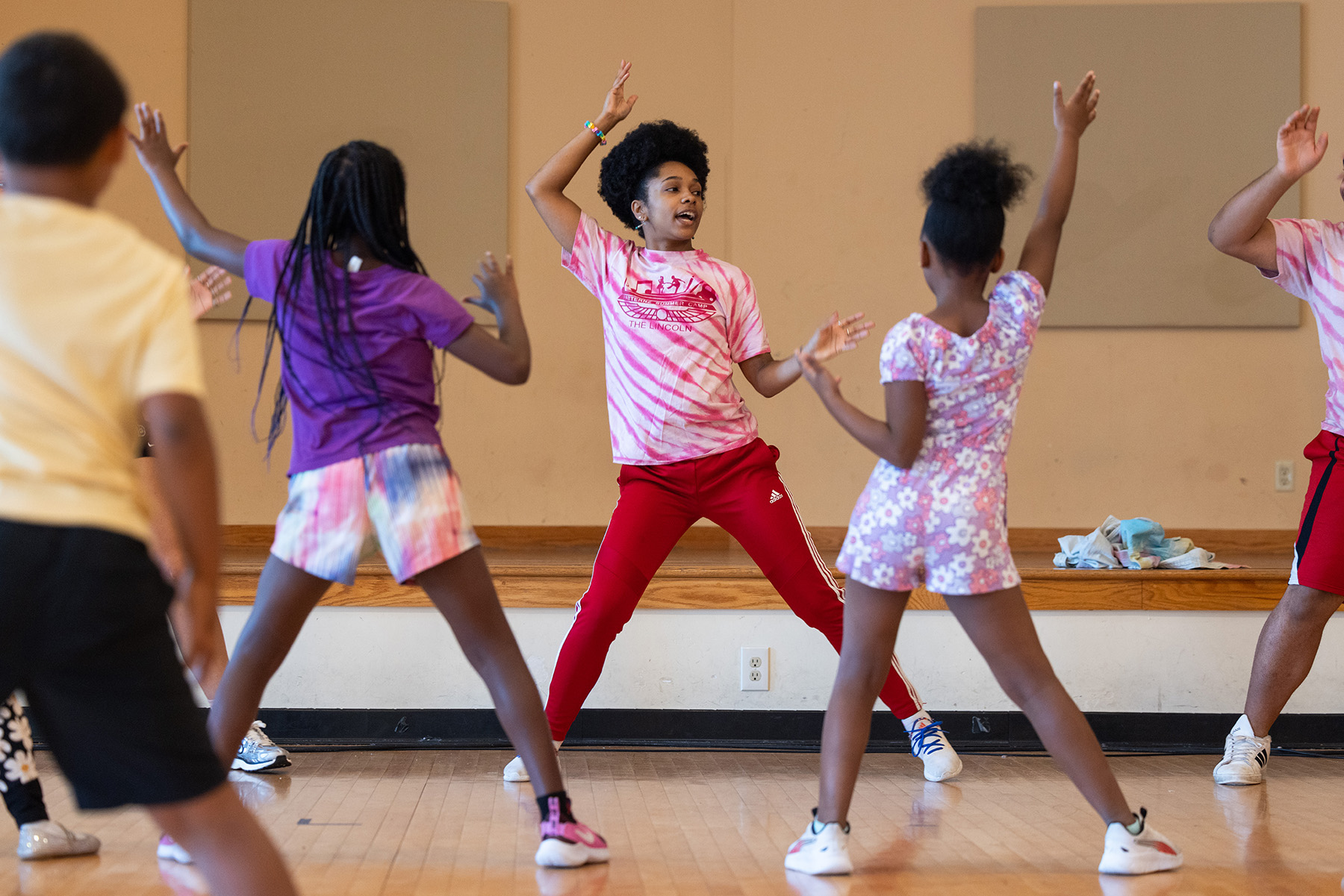 Brianna dances at the front of a classroom while young students copy her moves 