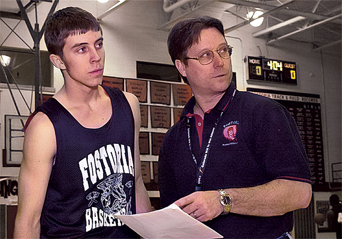 A teenage Jake stands with his dad on a basketball court; Jake is a player and his dad, a coach. Both look at something off camera.