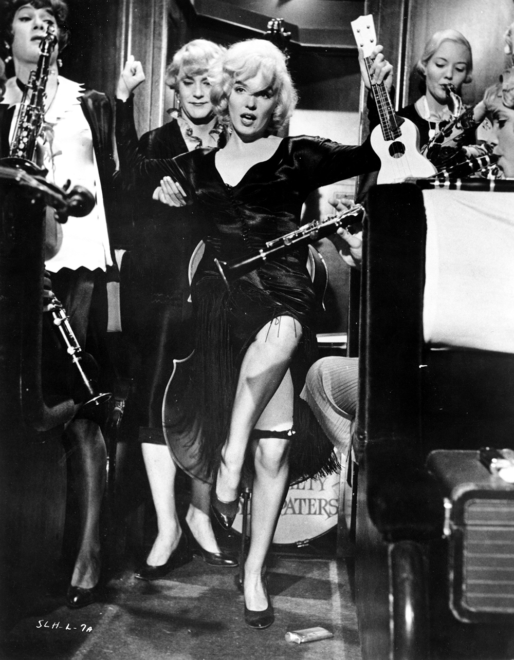 Marulyn Monroe dances among a group of women playing instruments