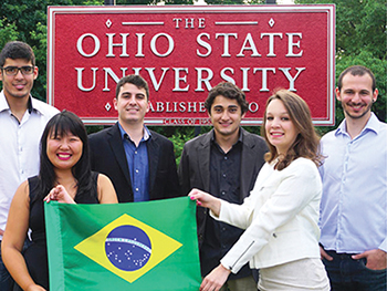 In front of a big sign that read “The Ohio State University,” two female students and four male students smile proudly as they hold up a Brazilian flag.