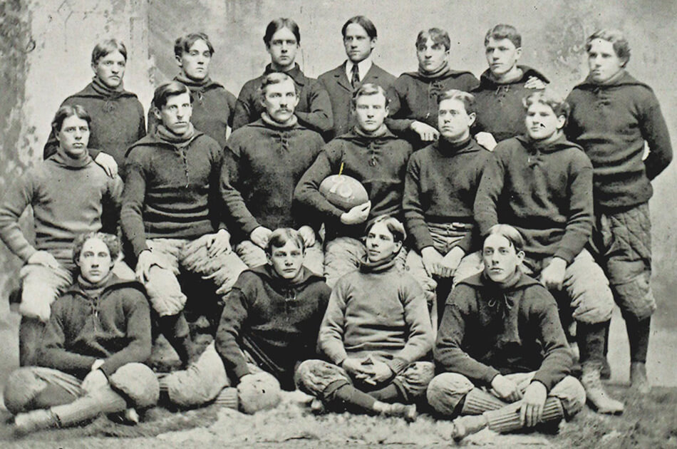 Black and white photo of 1895 football team. 17 white men pictured in 3 rows. All men dressed in uniform, except man in center in back row in suit. 