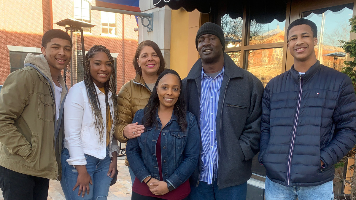 The Styles family poses for a family photo on a sunny day at Easton Town Center in Columbus, Ohio. Shown are the parents, Lorenzo C. and Laverna; their 2 sons, Lorenzo P. and Sonny; and two daughters. They’re all smiling happily and wearing light coats or jackets. 
