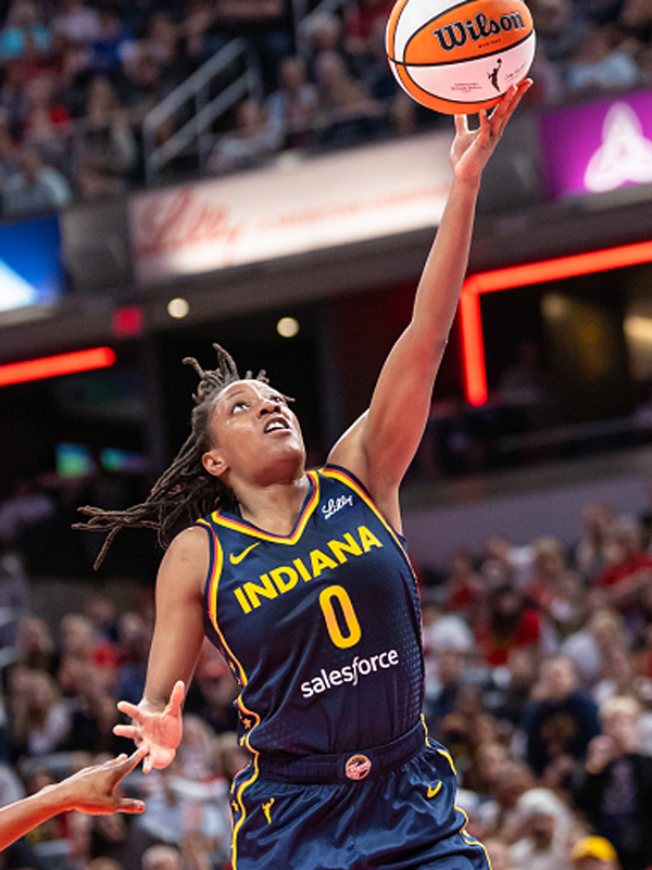 Kelsey Mitchell, a young Black woman, lays up the basketball to score two points for Indiana.