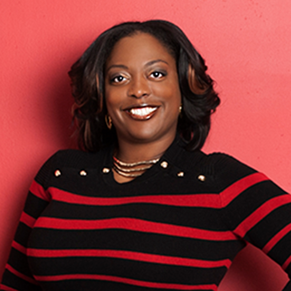 portrait of Shakita Trigg smiling wearing a red and black striped sweater