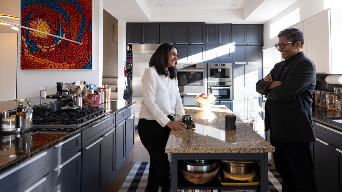 Bhakti Bani and her husband, Bharat Baste, stand and chat over the island in their tastefully designed kitchen at home. They’re both laughing and have cups of coffee in front of them.