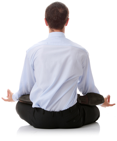 A man with his back to the viewer sits in a seated yoga position.