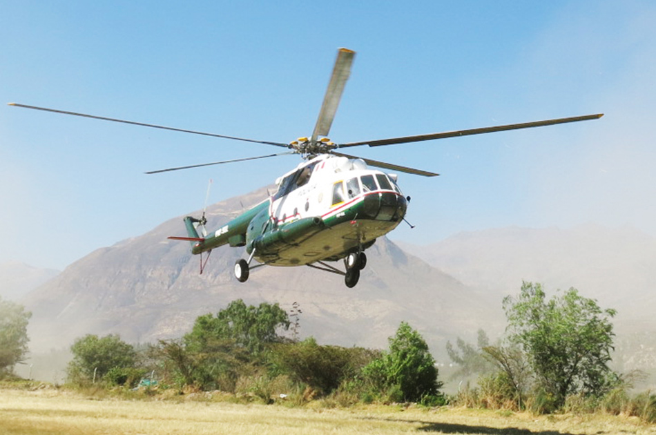 a helicopter carries the ice core samples off the mountain to be transported