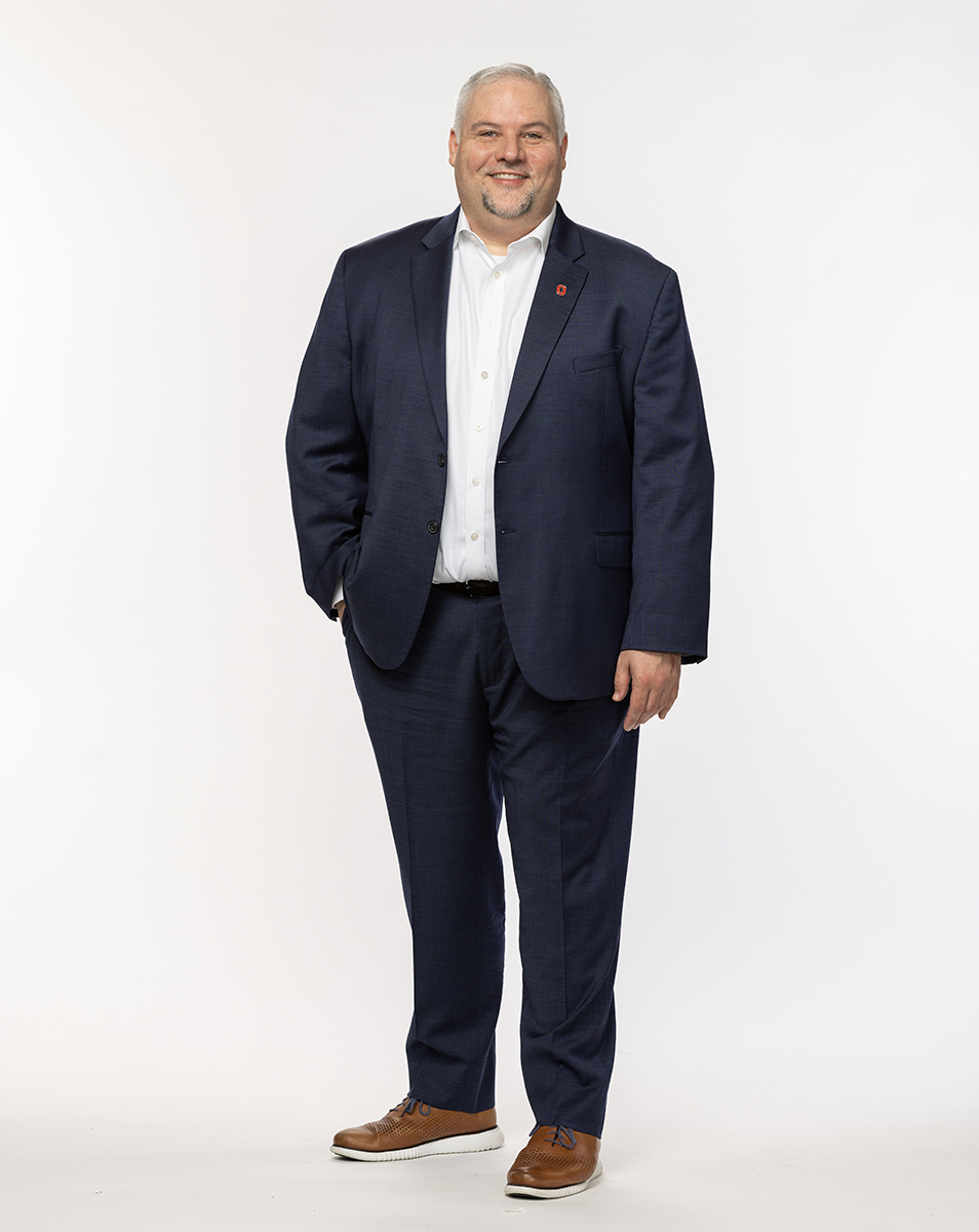 David Turkaleski is a white man with neatly shaped salt-and-pepper hair and goatee. Here he wears a suit with no tie and poses casually with one hand in a pocket. He's smiling like he is genuinely pleased to meet you.