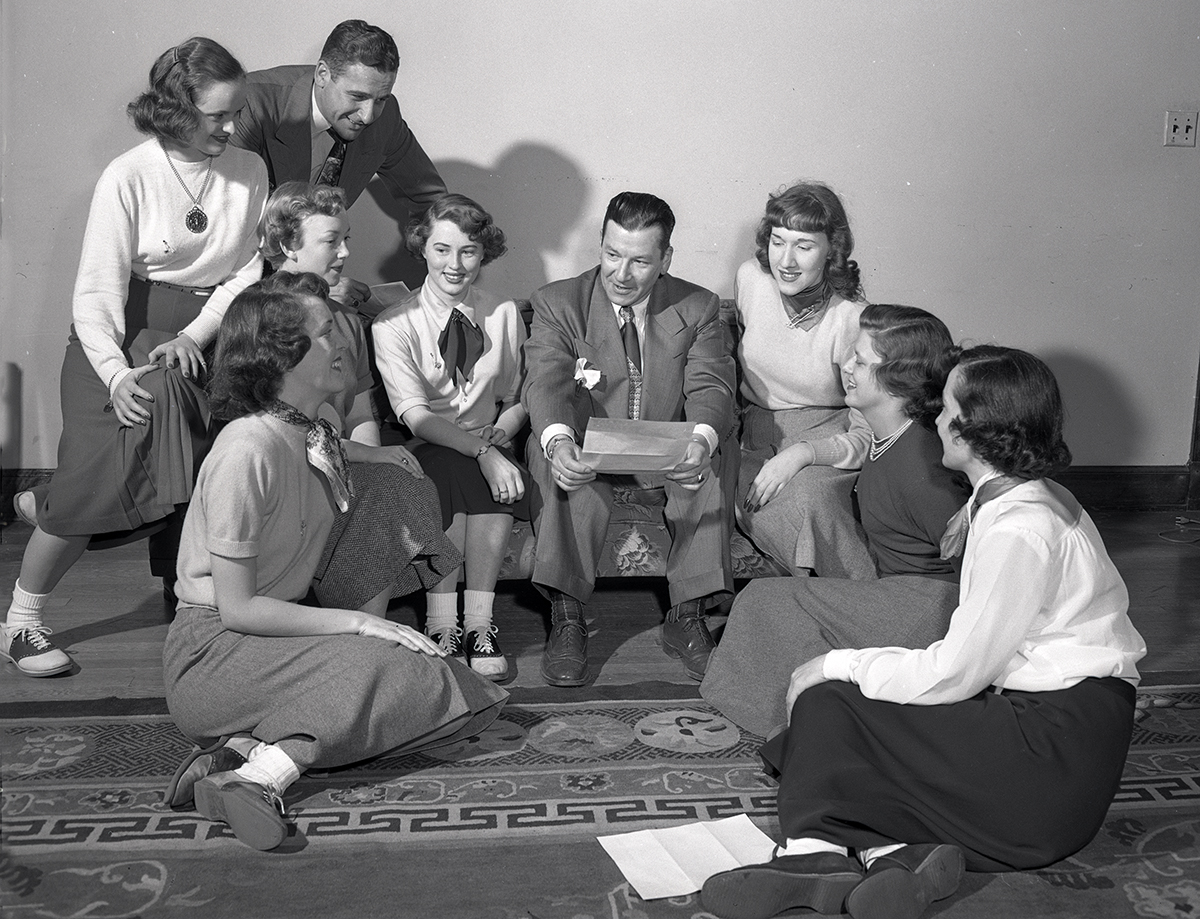 Group of students sitting around a man listening