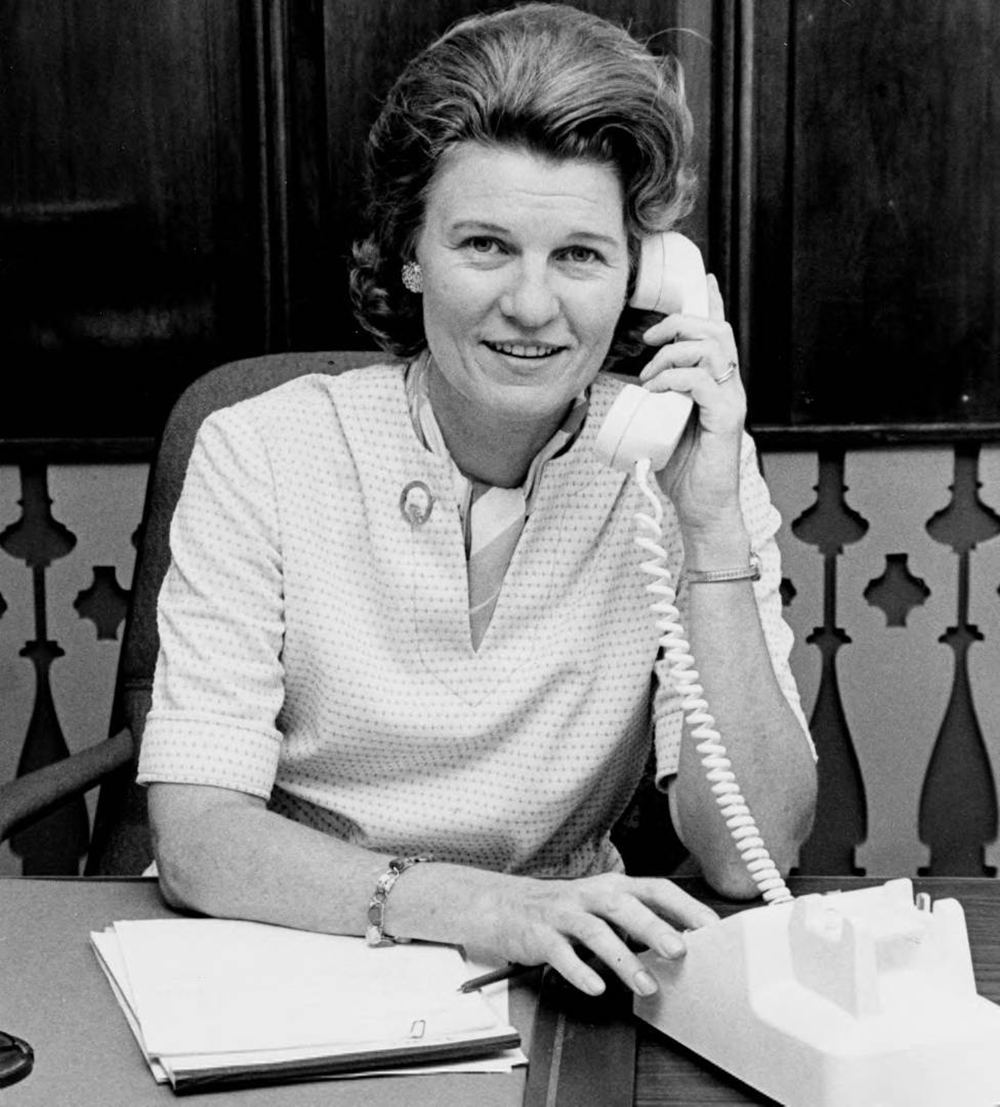 A young Dorothy Teater smiles for the camera as she speaks on an old rotary style telephone.