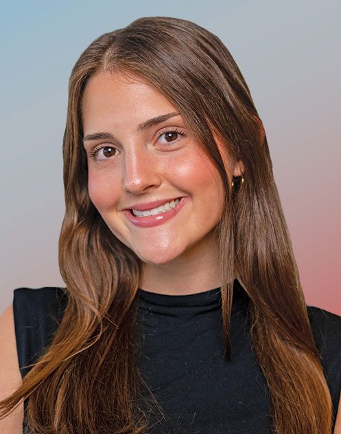 A young woman with long hair smiles as she looks directly into the camera