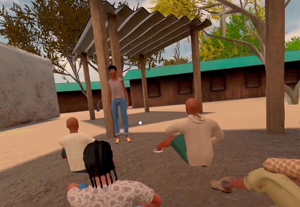 A screenshot of a virtual reality project shows children sitting on dirt listening to a teacher. There are a few buildings around them and overhead, corrugated metal on tall wooden pillars, which provide shade. 