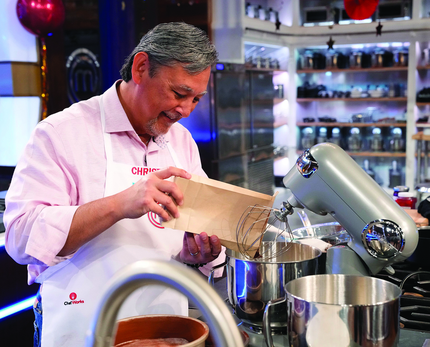 Chef Chris Walinski pours flour into a mixing bowel while making his much praised cake on the television show.