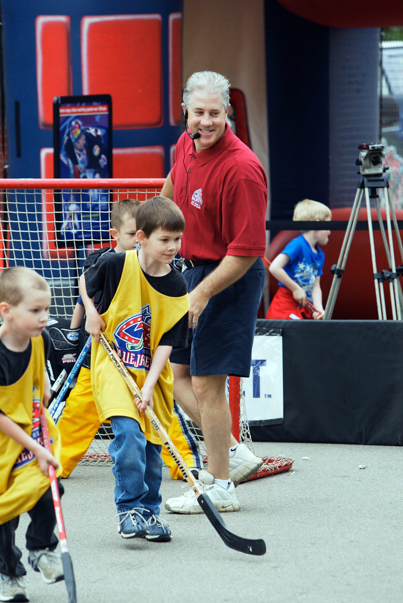 Bill Davidge smiles as he watches kids play hockey.
