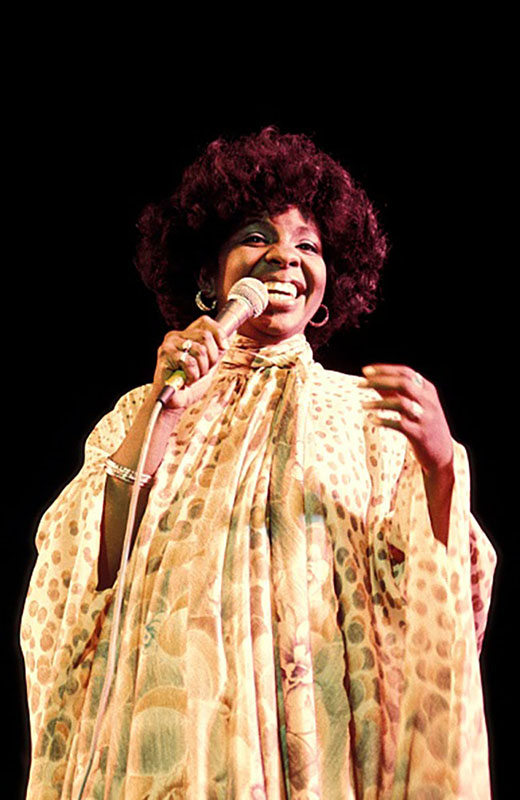 Gladys Knight holds a microphone during a concert