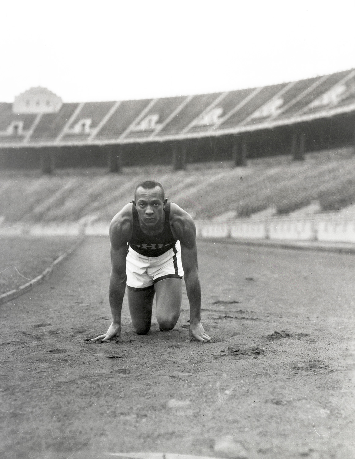 Jesse Owens crouches while getting ready to start a race