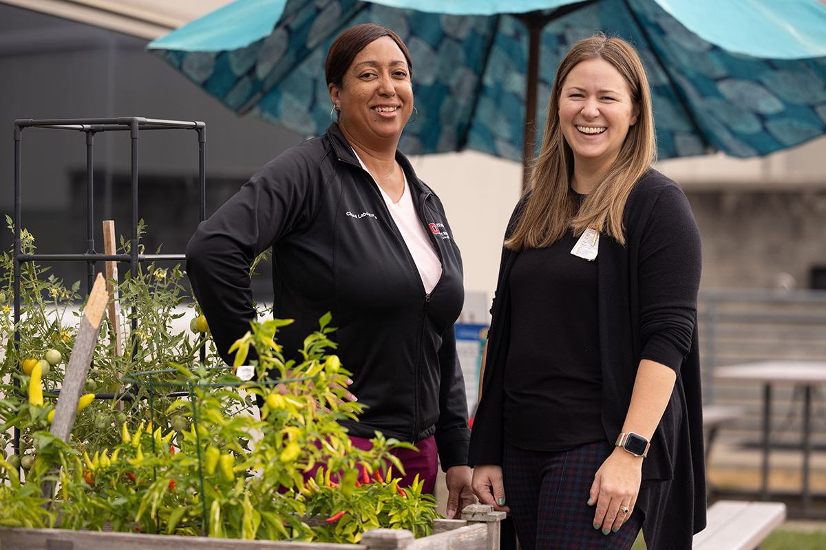  Two Ohi oState employees grin as they stand among their container garden.