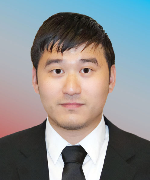 An Asian man wearing a formal suit, dress shirt, and tie, shown from the shoulders up against a plain backdrop