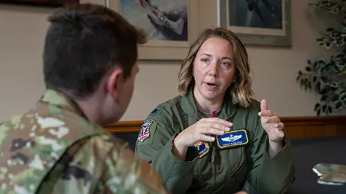 a man and woman in military uniforms talking at a table