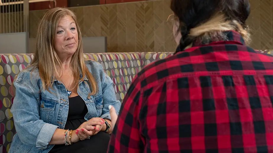 woman in jean jacket talking to girl in flannel