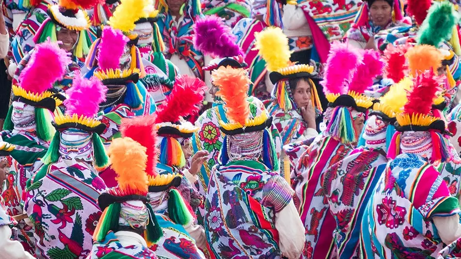 group of females dressed in colorful attire with feather hats