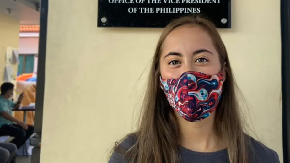 Woman wearing cloth mask with multi-colored patten and gray t-shirt