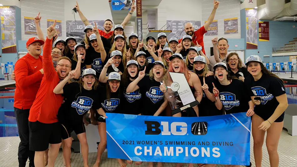OSU women's swimming team celebrating as a group with trophy and banner