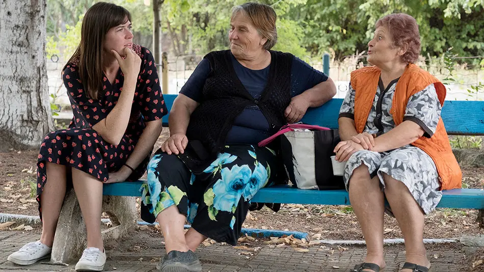 three women talking on a bench