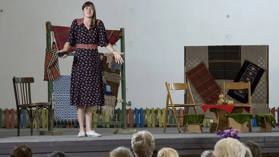 woman stands on stage in front of audience