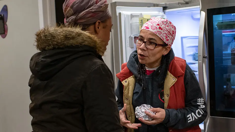 Esther Flores giving food to a woman in need
