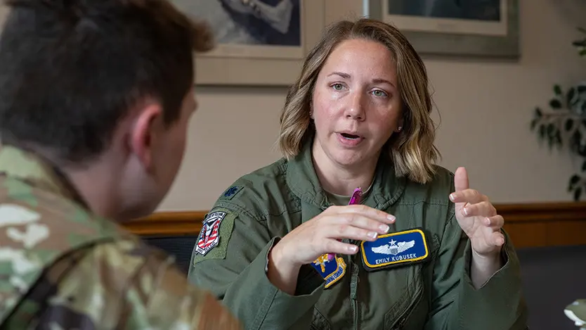 female talking to male on the left and two headshots of male soldiers on the right