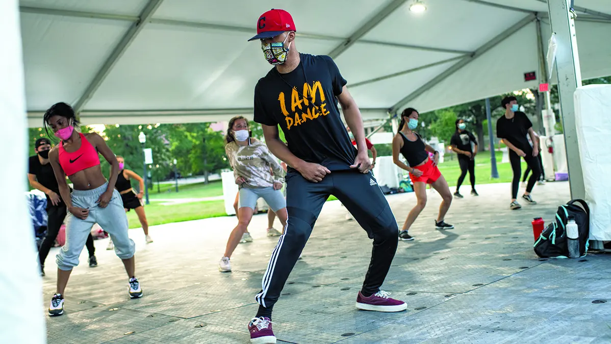 Group dance class outside under a tent