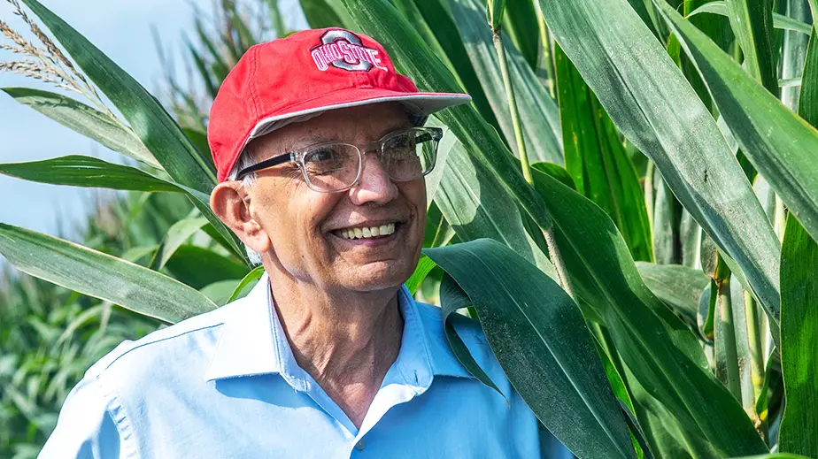 Rattan Lal stands in a field of corn