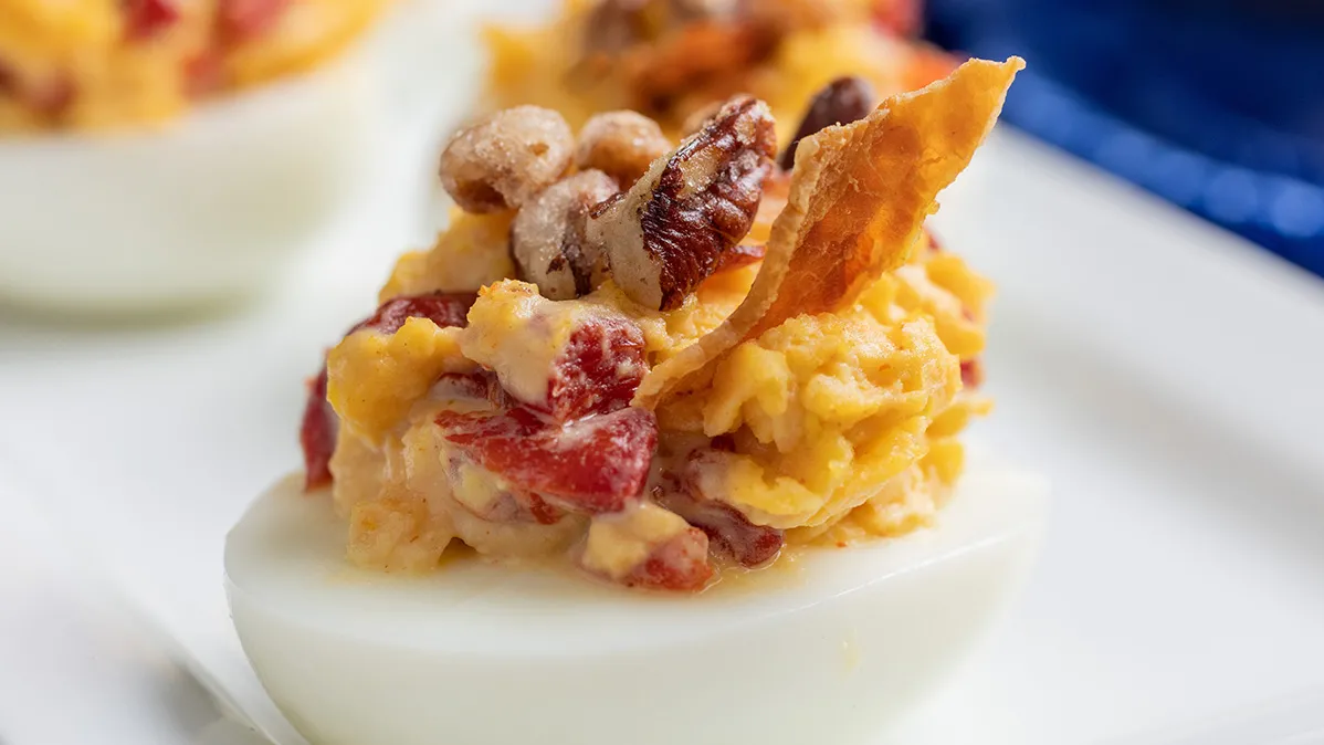 Deviled egg topped with bacon and pecans