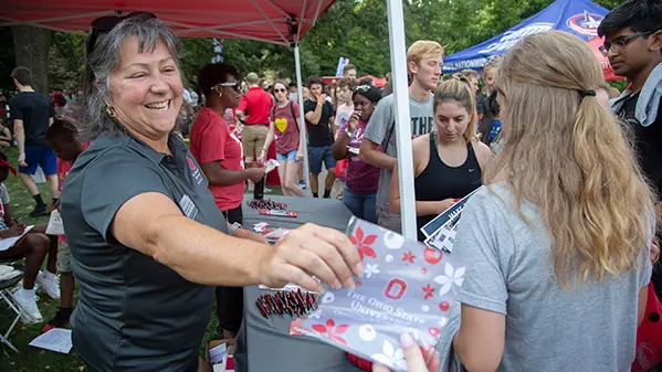 Molly Ranz Calhoun handing out Ohio State materials to students at a booth