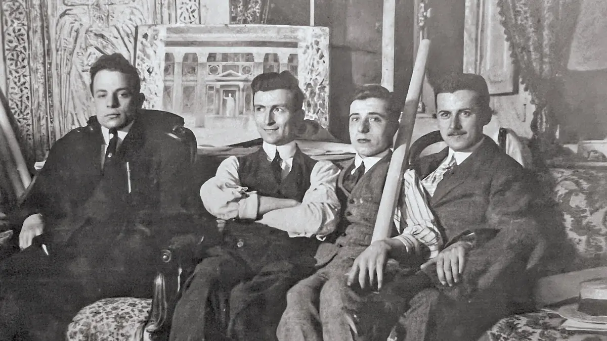 In a black and white photo that is more than 100 years old, four well-dressed white men sit on a plush, patterned sofa. Howard Dwight Smith stands out because he is the only one with arms crossed, looking off to the side, and 6smiling.
