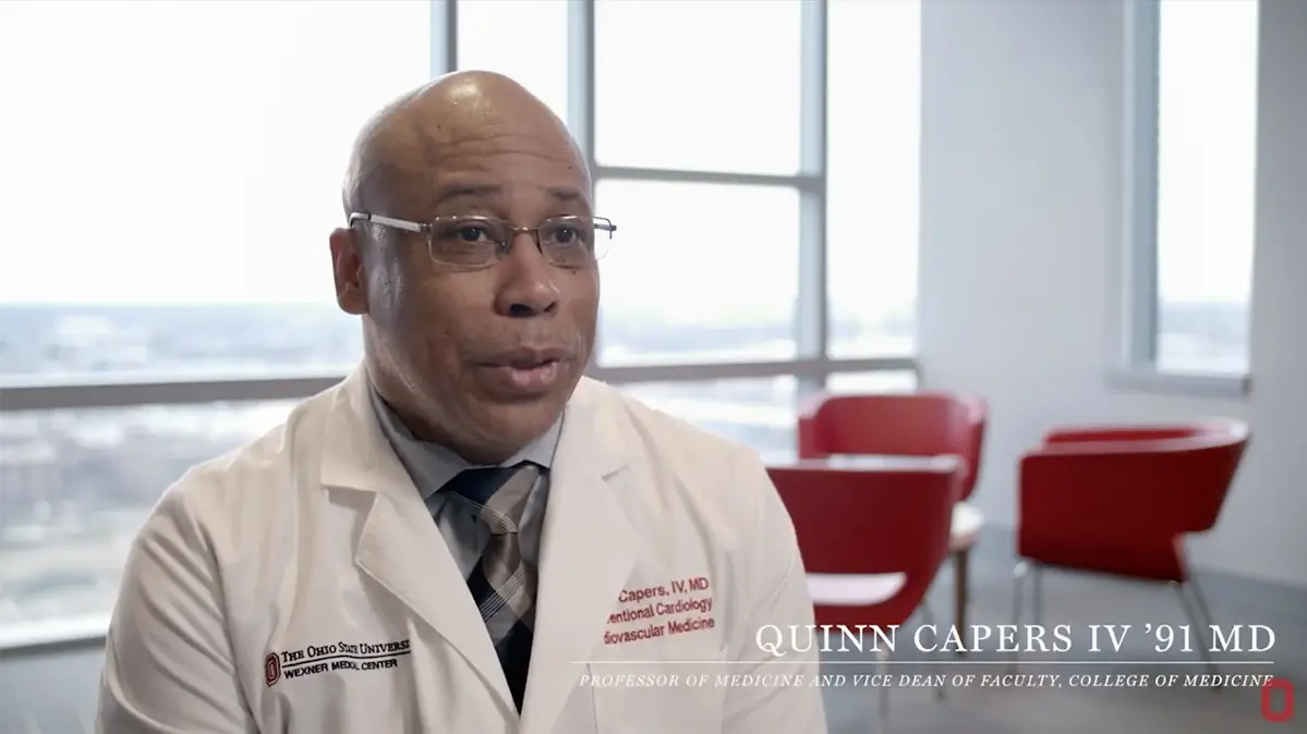 A still from video showing Dr. Quinn capers speaking to the camera