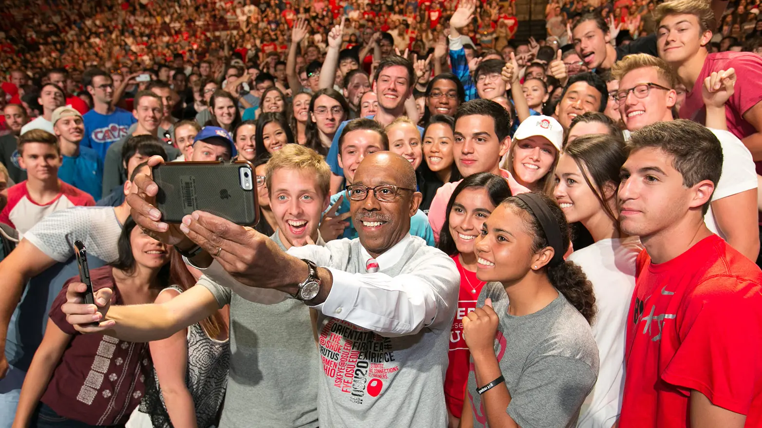 President with phone camera takes selfie with huge group of students surrounding