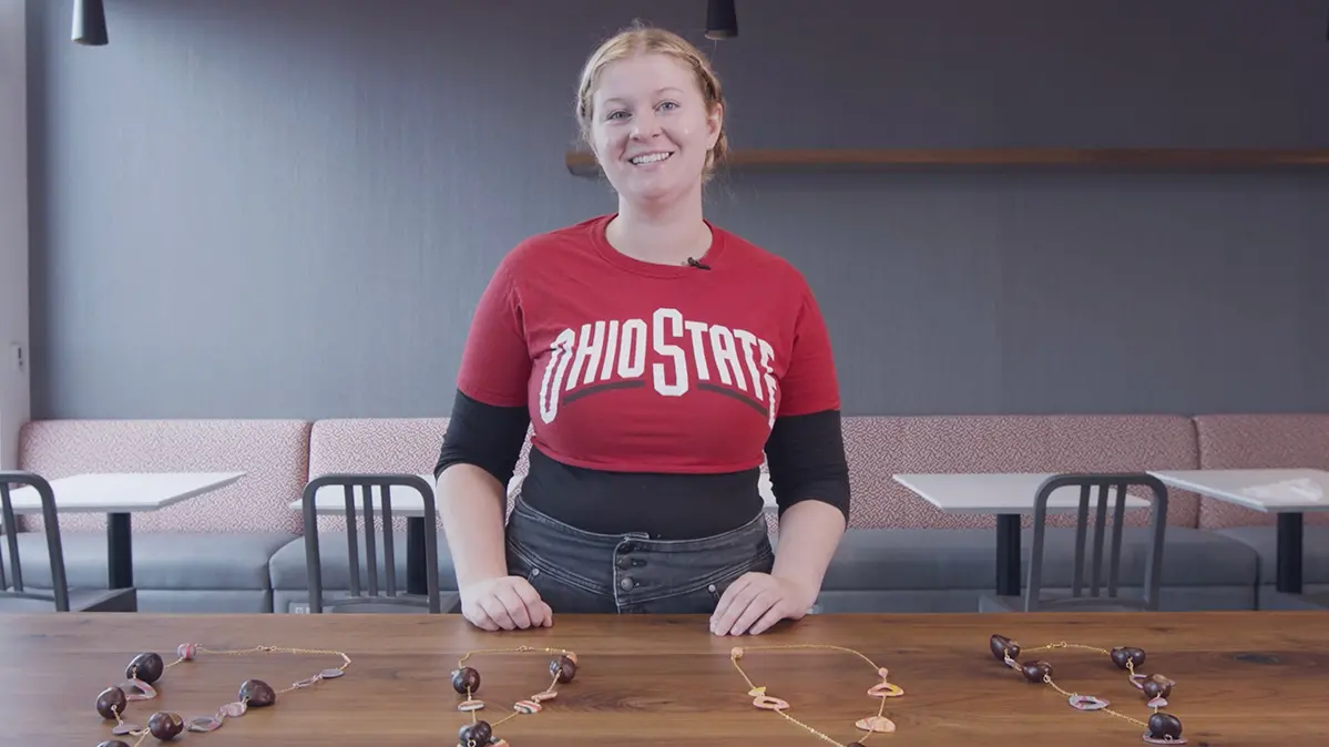 Clay artist Lizzie Howald with her necklace creations laid out on a table in front of her