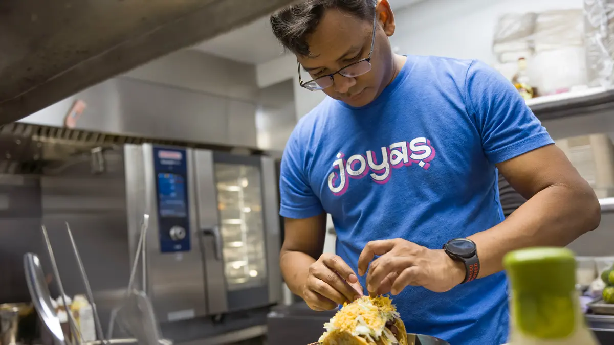 A man wearing glasses and a Joya’s T-shirt intently arranges tacos that are stuffed so full, your face would get messy when you try to take a bite. Deliciously messy.