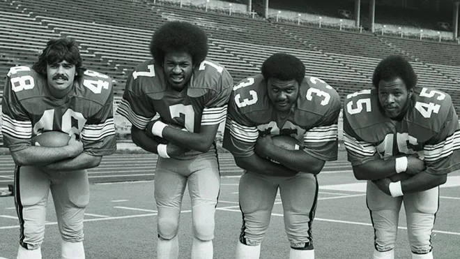 four ohio state football players stand side-by-side in full uniform